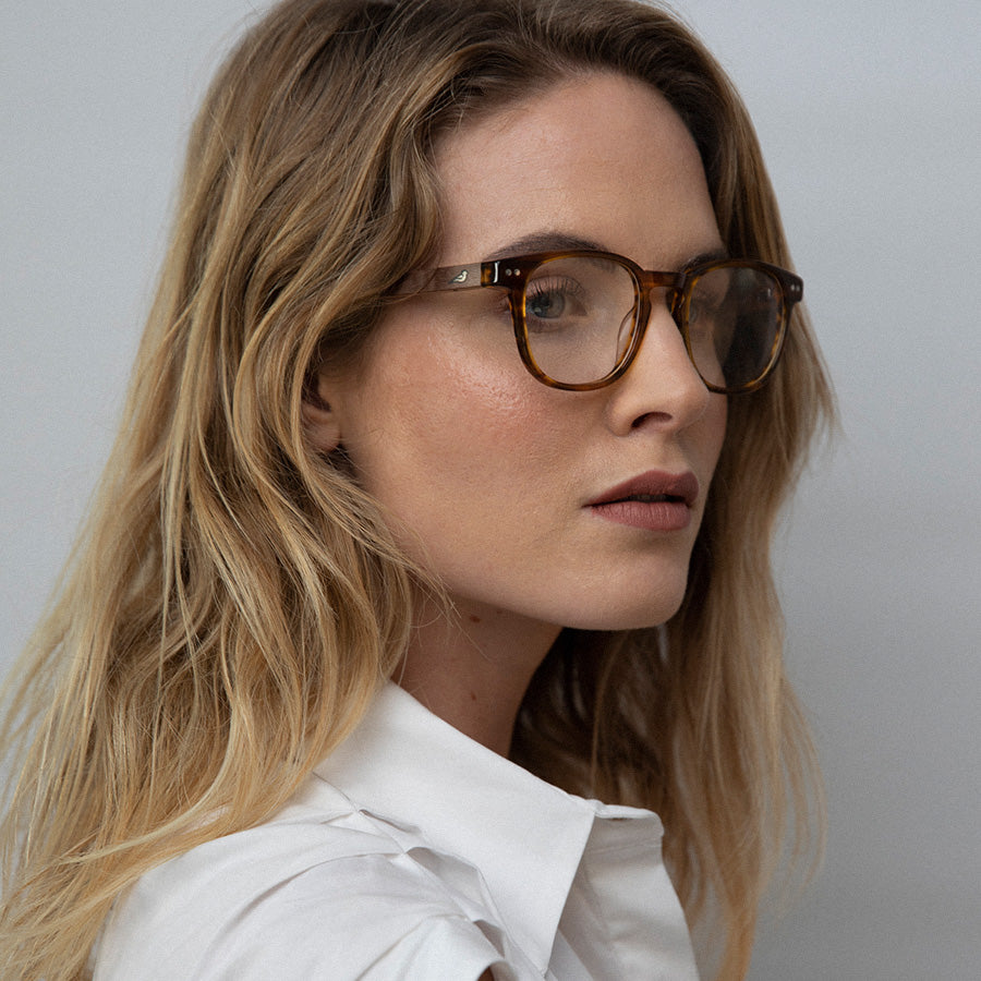 Woman facing sideway wearing caramel rectangle small glasses 