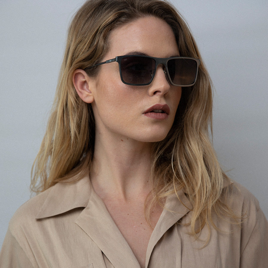 Woman wearing metal rectangle sunglasses looking sideways