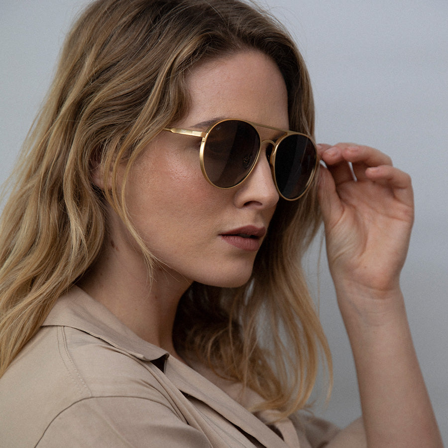 Woman looking down wearing large aviator sunglasses with polarised lenses