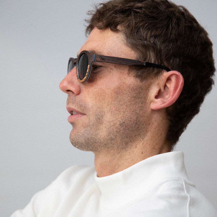 Man wearing eco friendly round wooden sunglasses with polarised lenses facing sideways