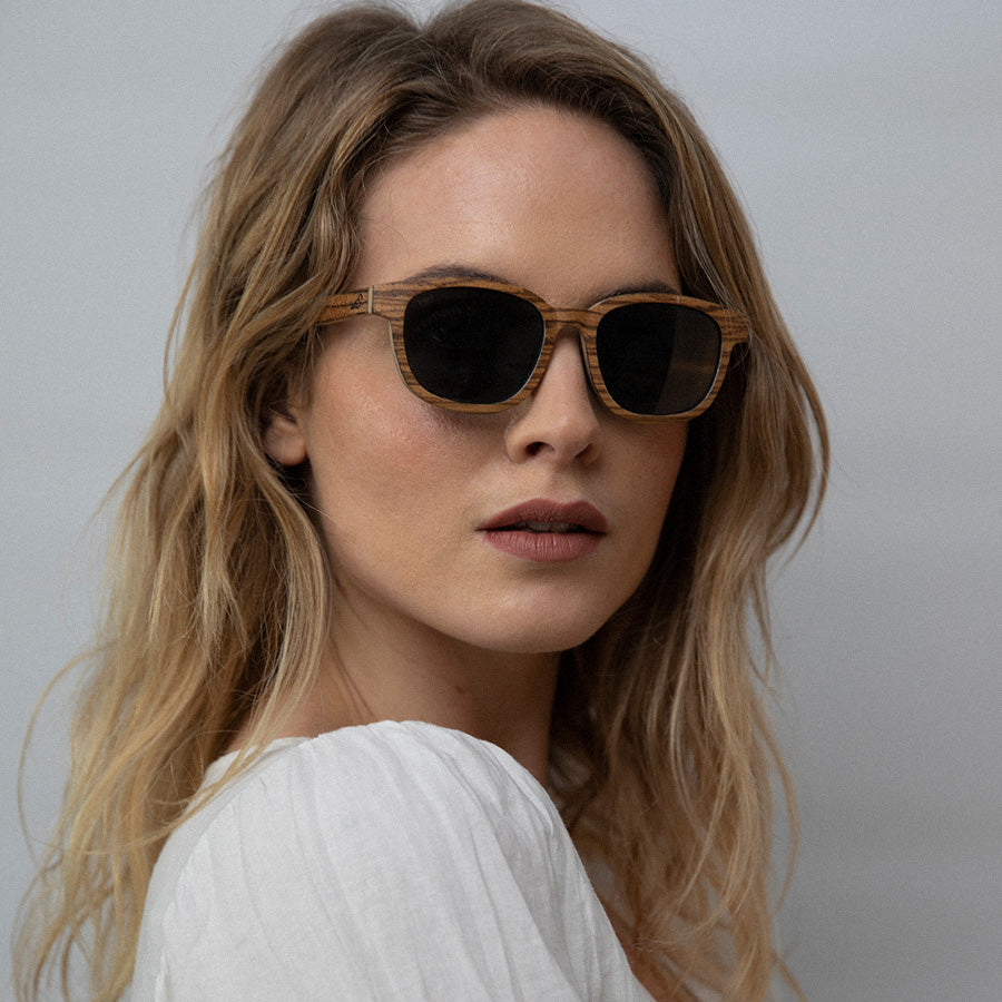 Woman wearing  Eco conscious wooden sunglasses with light coloured wood