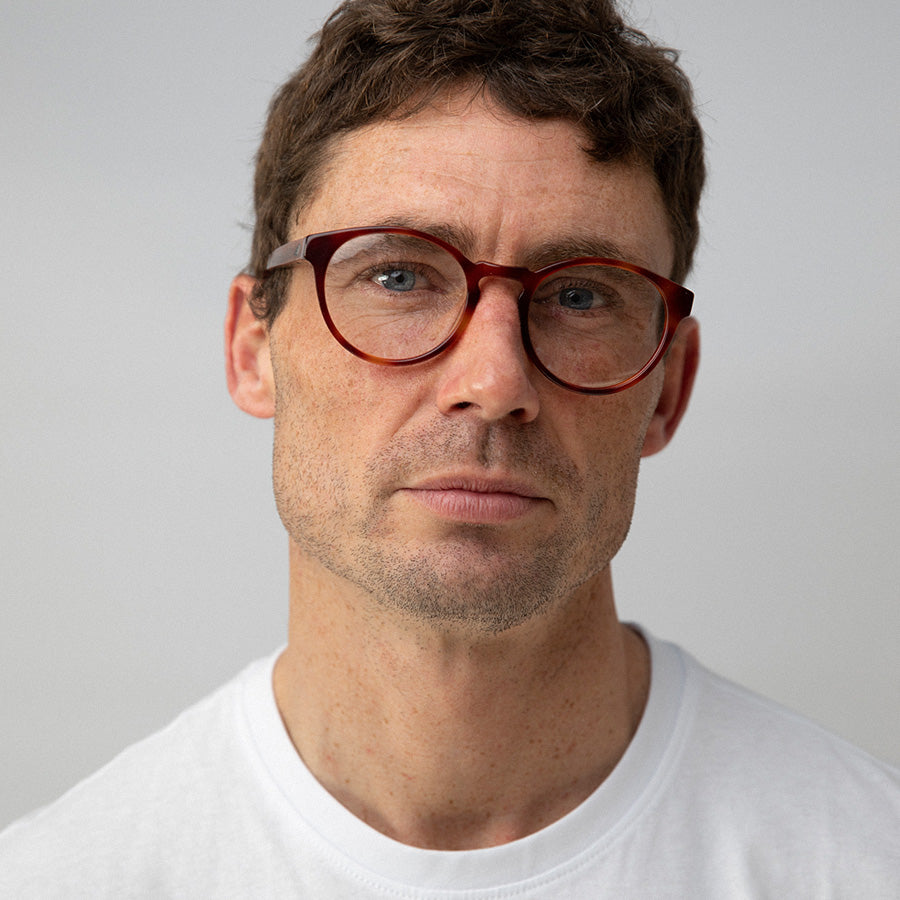 Man wearing red rimmed glasses made from sustainable acetate