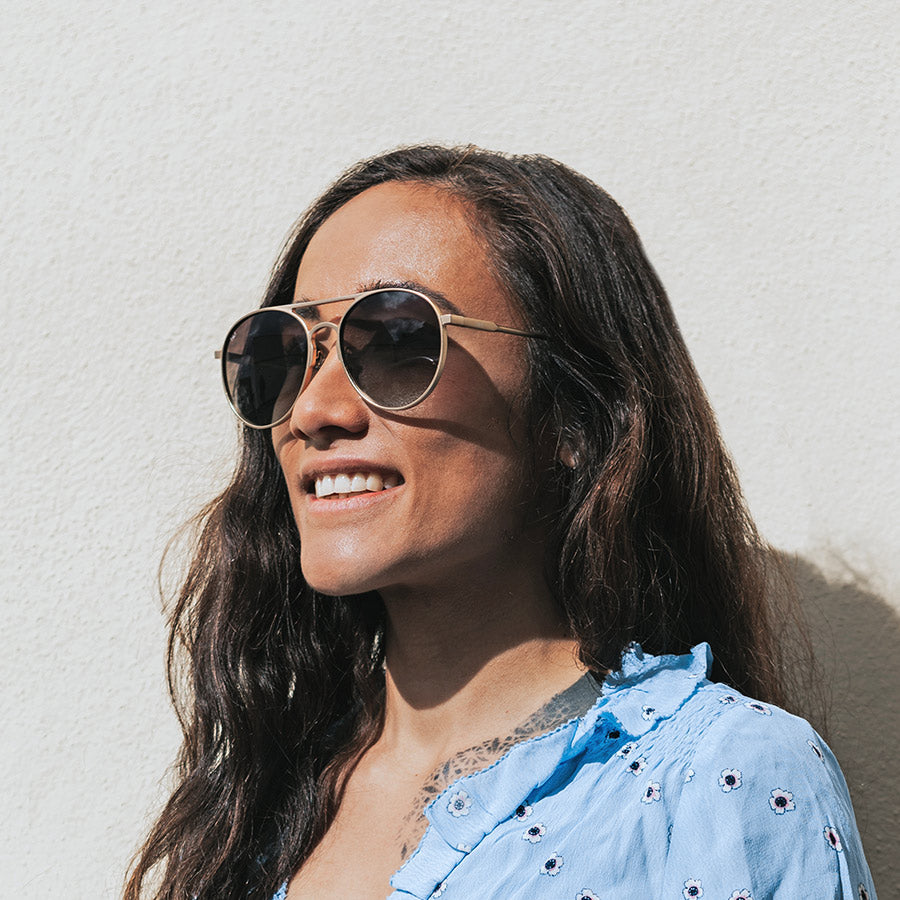Women standing in the sunshine wearing large aviator sunglasses with polarised lenses