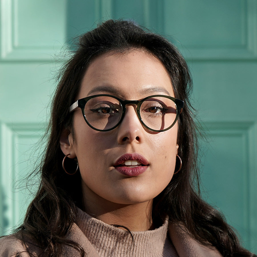 Girl wearing sustainable olive green glasses